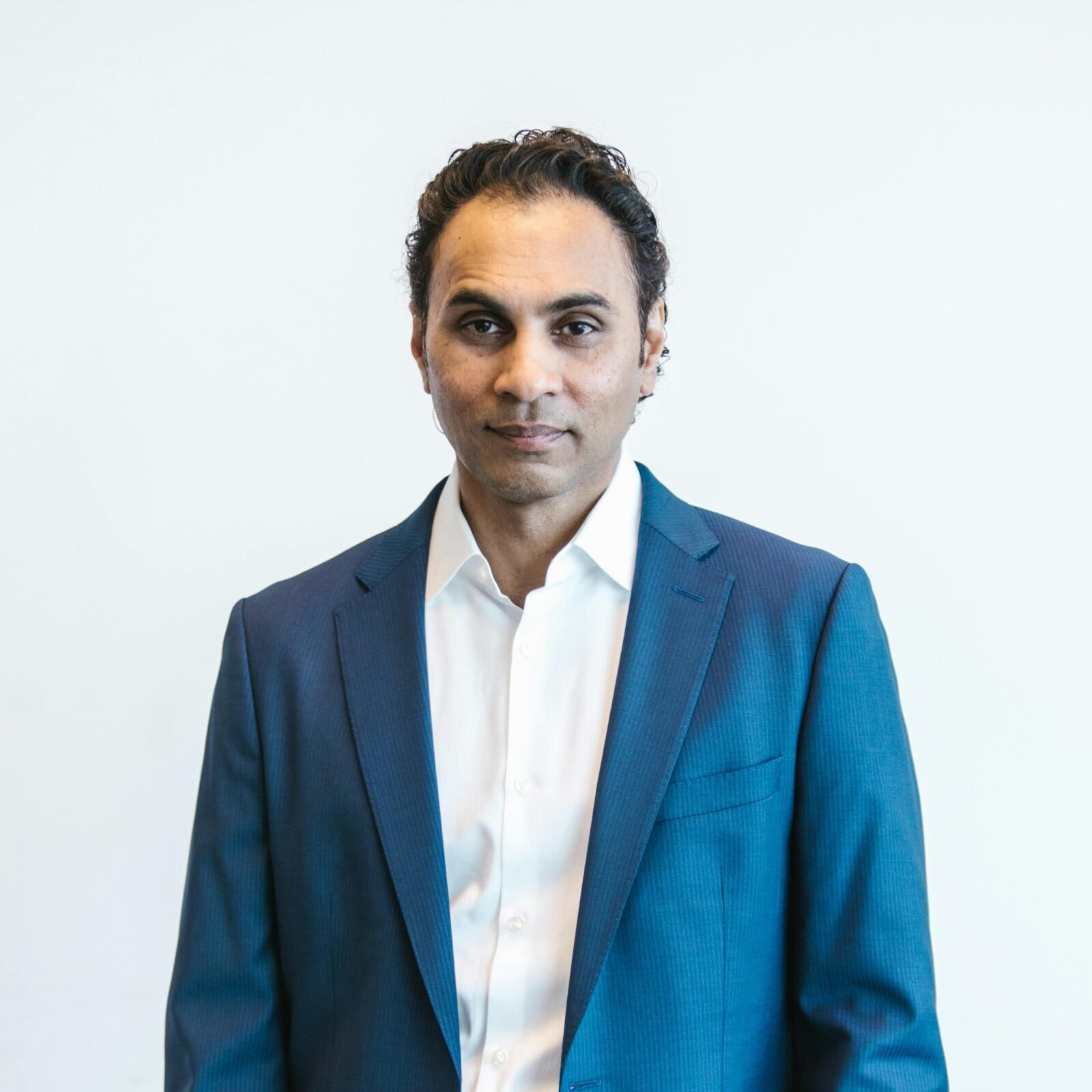 Portrait of a confident businessman holding papers in formal attire inside an office